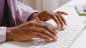 close up of hands getting ready to type on a white keyboard