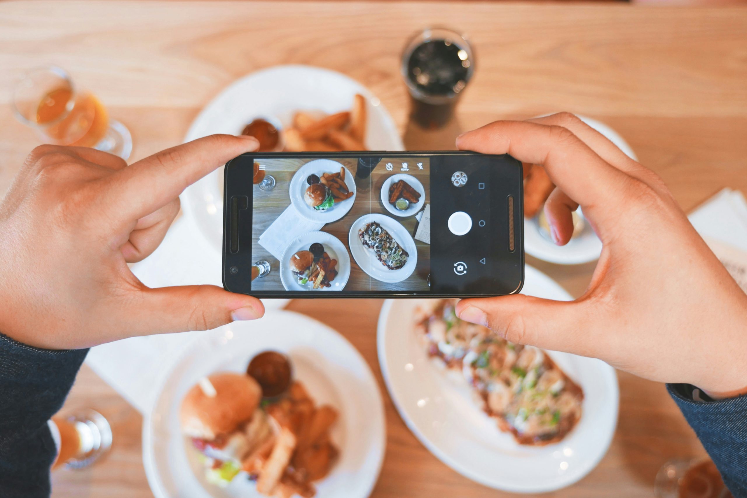 Someone taking a picture of their plate of food at a restaurant.